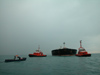 La barca degli ormeggiatori sta passare la cima di ormeggio della piattaforma off-shore del porto petroli di Multedo